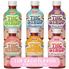Set of five bottles of 'The Syrup' with different flavors on a white background.