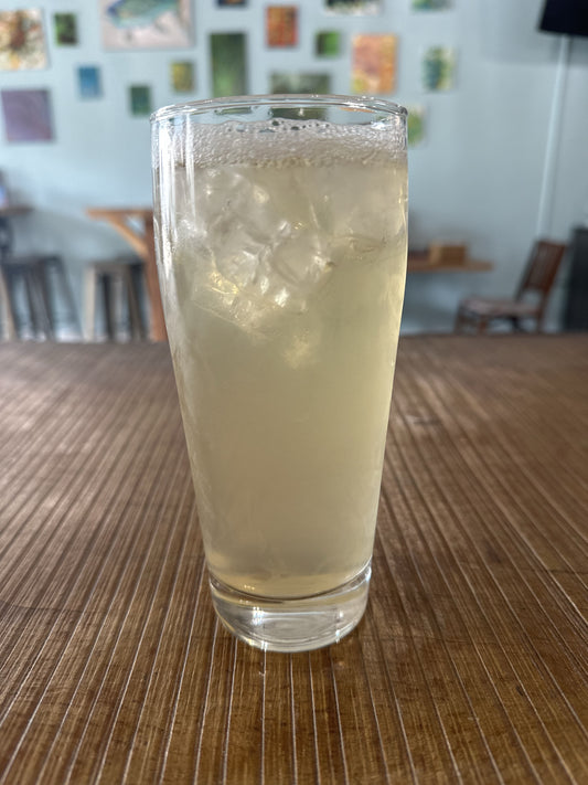 Glass of k-tea with ice on a wooden table, blurred background