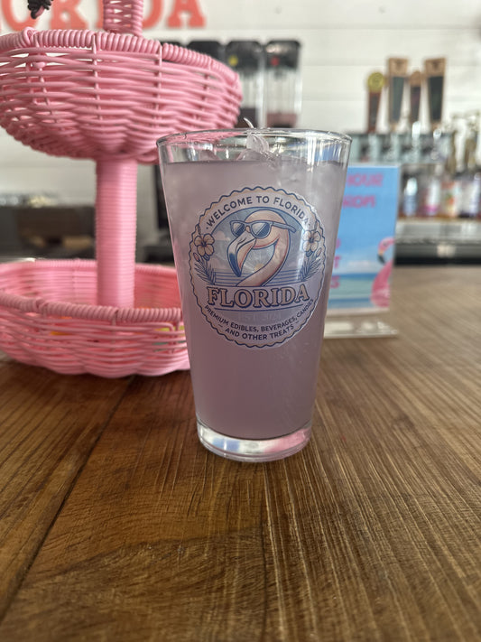 Pint glass with 'Welcome to Florida' design on a wooden table